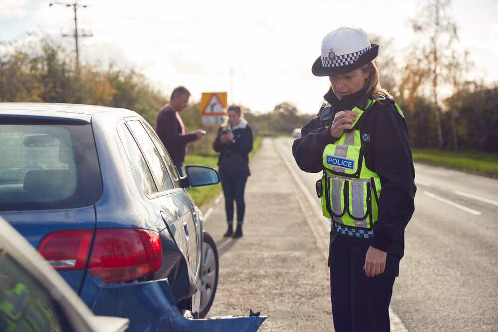 Woman police officer checking on car accident.