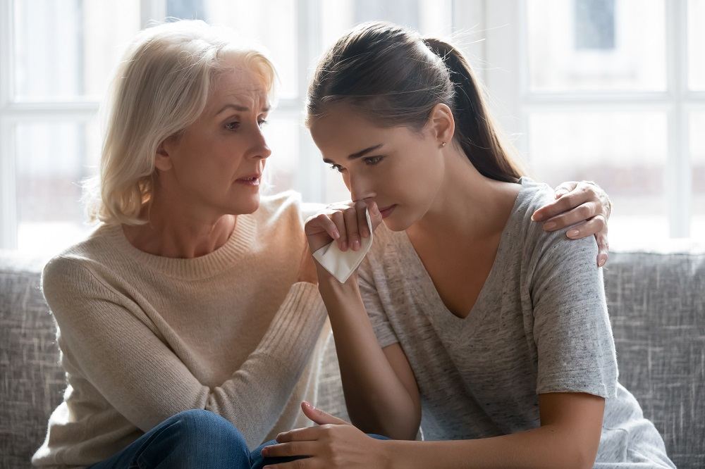 Mother comforting her crying daughter.