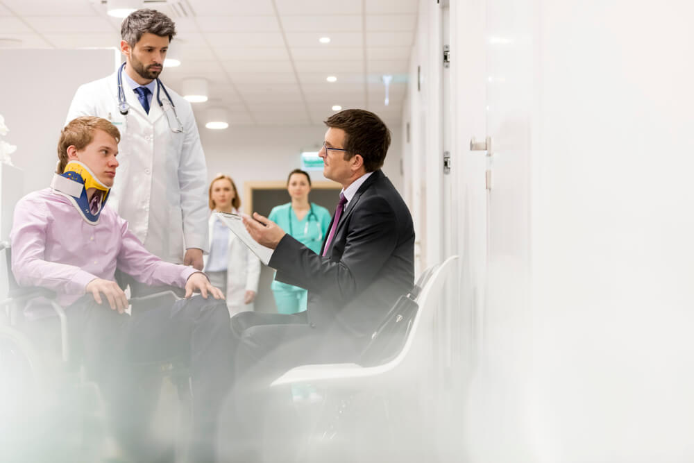 Injured client with his doctor on the side, talking to his lawyer for claim.